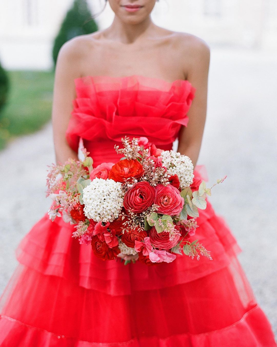 váy cưới thời trang cao cấp màu đỏ với vải tuyn xù và bó hoa cô dâu màu đỏ hiện đại