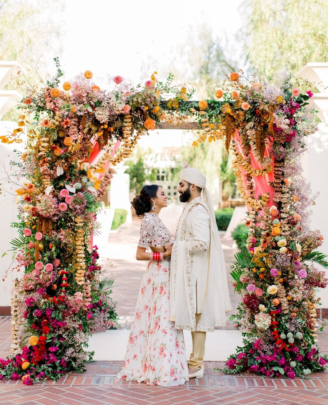 vibrant Indian mandap with carnation garlands and dyed flowers
