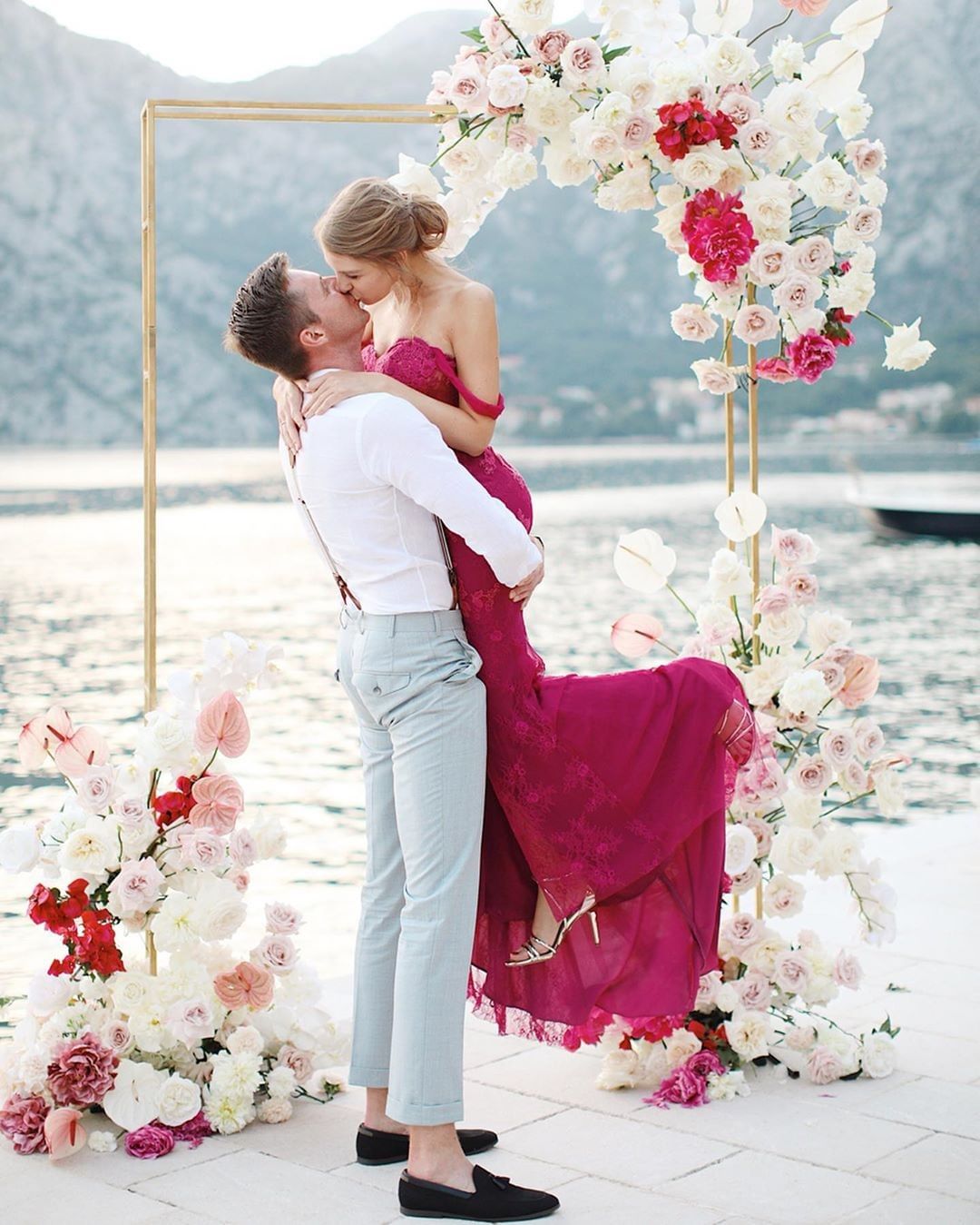 pink wedding dress for a lakeside wedding ceremony with a modern gold and fresh flower backdrop